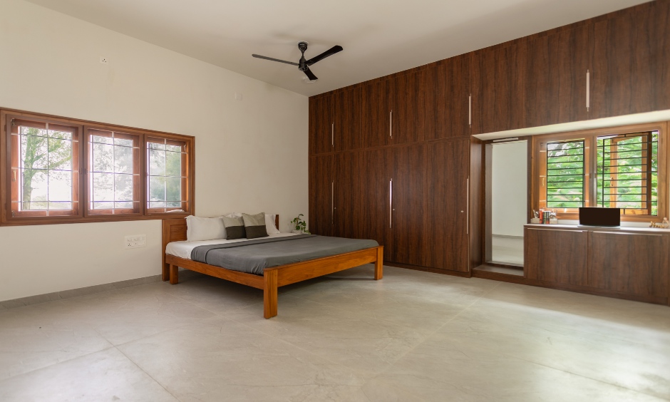 2BHK minimalist bedroom with dark wood wardrobe and wooden bed in Vishweshwara Nagar, Coimbatore