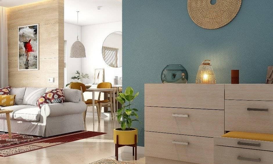 The interior design of the 2bhk foyer wall in teal colour with coir wall art lends a boho vibe