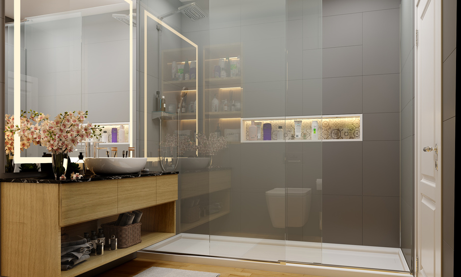 Minimalist bathroom interior featuring huge strip mirror, rose-gold lighting, and glass partition shower.