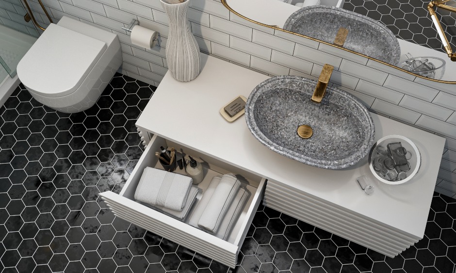 Retro bathroom design with stone sink, gold framed mirror, and storage underneath.